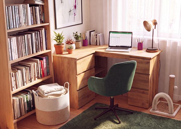 Namų biuras su mediniu kampiniu ra&scaron;omuoju stalu, ergonomi&scaron;ka žalia biuro kėde, ne&scaron;iojamuoju kompiuteriu, knygų lentyna, staline lempa ir kambariniais augalais, kuriantis patogią ir produktyvią darbo vietą darbui i&scaron; namų.