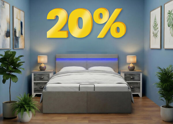 Reklaminis skydelis su &bdquo;20 %&ldquo; nuolaida dideliais geltonais 3D skaičiais vir&scaron; moderno miegamojo su pilka lova, mėlynomis sienomis ir augalais prie lovos. Spustelėkite ir peržiūrėkite kolekcijos prekes.