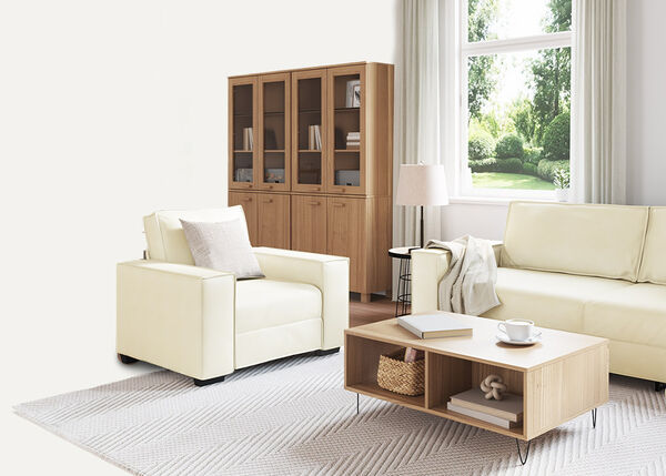 Balta dvivietė sofa su pagalvėlėmis ir antklode, skirta patalpoms.