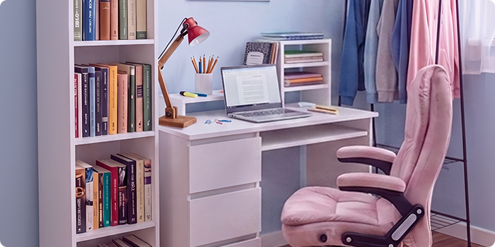 Šiuolaikiška studento mokymosi erdvė su baltu rašomuoju stalu, ergonomiška biuro kėde, nešiojamuoju kompiuteriu, knygų lentyna, daiktų laikymo spintele ir drabužių kabykla šviesiame, tvarkingame miegamajame, pritaikytame patogiam mokymuisi ir kasdieniam studento gyvenimui.
