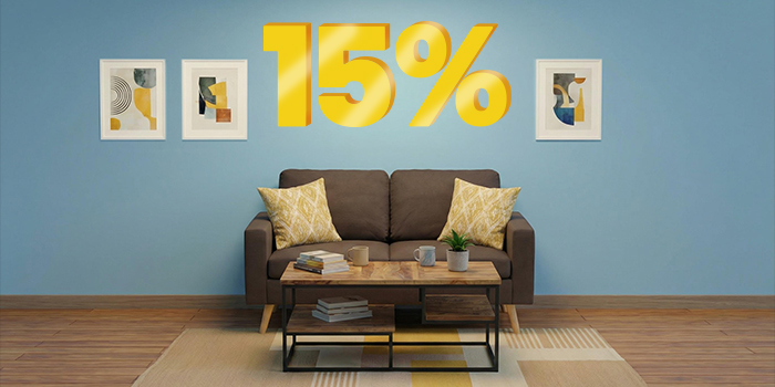 Reklaminis skydelis su „15 %“ nuolaida dideliais geltonais 3D skaičiais virš svetainės su ruda sofa, geltonomis pagalvėlėmis, mediniu kavos staliuku ir trimis įrėmintais paveikslais ant mėlynos sienos. Spustelėkite ir peržiūrėkite kolekcijos prekes.